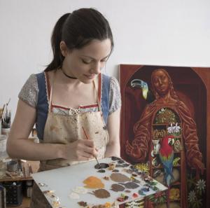 Madeline Von Foerster in her studio with her painting "Amazon Cabinet" in the background. 